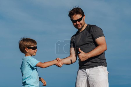 Foto de Feliz padre e hijo dan la mano, regocijándose en su éxito - Imagen libre de derechos
