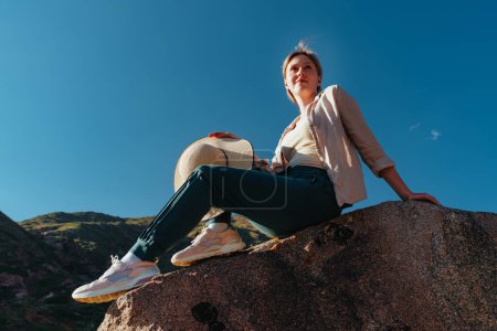 Téléchargez les photos : Jeune femme randonneuse assise au sommet de la montagne - en image libre de droit
