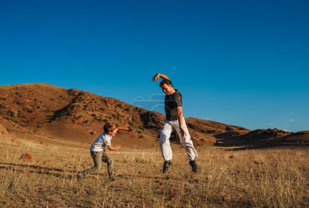 Foto de Padre e hijo entrenamiento de artes marciales para la diversión en el fondo de las montañas - Imagen libre de derechos
