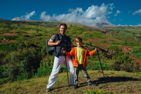 Photo for Happy father and son hikers standing on the mountain - Royalty Free Image
