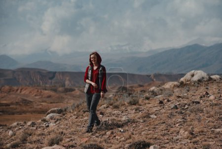 Photo for Young smiling woman tourist walks in the mountains - Royalty Free Image