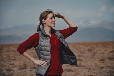 Photo for Young woman tourist in the mountains looking into the distance - Royalty Free Image