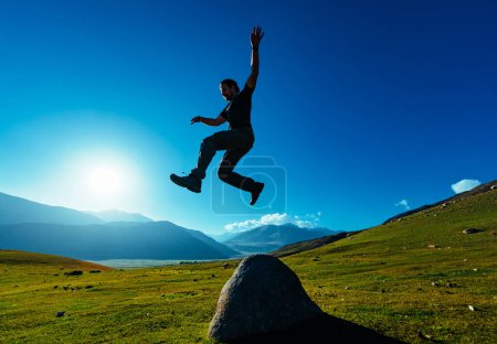 Téléchargez les photos : Jeune homme sportif sautant sur fond de montagnes - en image libre de droit