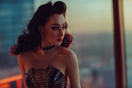 Téléchargez les photos : Portrait de jeune femme sexy brune de style rétro en corset noir sur fond de fenêtre - en image libre de droit