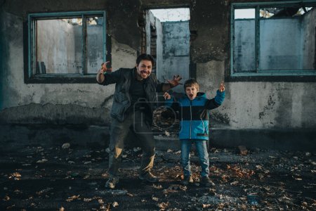 Téléchargez les photos : Père et fils grimaçant devant un immeuble en ruine - en image libre de droit