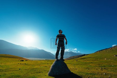 Photo for Handsome successful man standing on big stone in mountains - Royalty Free Image