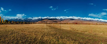 Foto de Panorama otoñal con campo sobre fondo montañoso en Kirguistán - Imagen libre de derechos