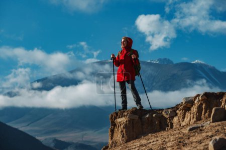 Foto de Joven turista de pie en la cima de la montaña y mirando hacia otro lado - Imagen libre de derechos