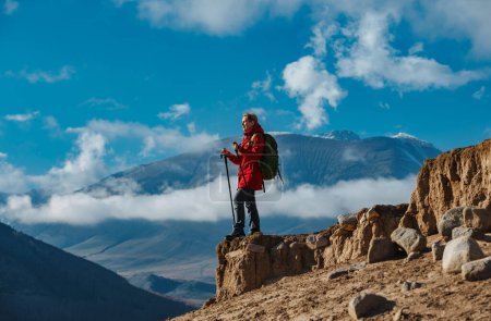 Téléchargez les photos : Jeune femme touriste debout au sommet de la montagne et regardant loin - en image libre de droit