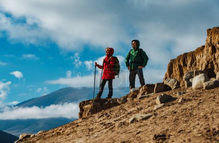 Foto de Pareja de turistas parados en la cima de la montaña y mirando hacia otro lado - Imagen libre de derechos