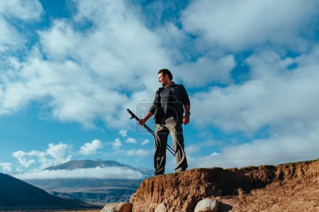 Foto de Joven turista de pie en la cima de la montaña con bastones de trekking - Imagen libre de derechos