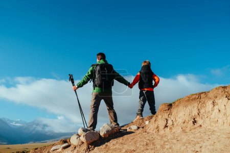Téléchargez les photos : Touristes père et fils sur le sommet de la montagne vue arrière - en image libre de droit