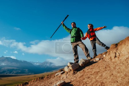 Téléchargez les photos : Heureux succès père et fils touristes sur le sommet de la montagne - en image libre de droit