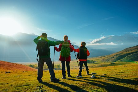 Téléchargez les photos : Randonnée en famille dans les montagnes par une journée ensoleillée à l'automne, vue sur l'arrière - en image libre de droit