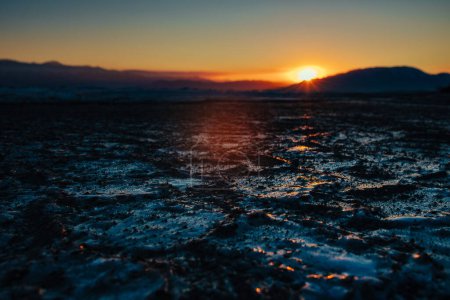 Téléchargez les photos : Glace noire sur le lac par temps froid d'hiver, lumière spectaculaire du coucher du soleil - en image libre de droit