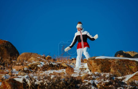 Photo for Young woman hiker walking down the mountain in winter - Royalty Free Image