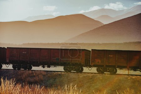 Photo for Freight wagons on mountains background at sunset - Royalty Free Image