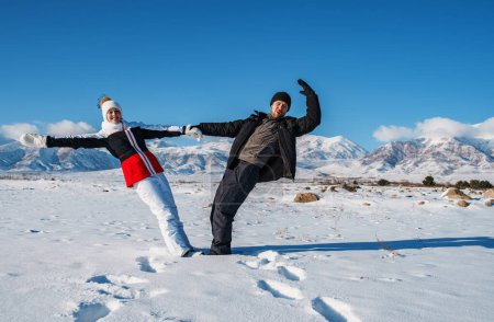 Téléchargez les photos : Jeune couple heureux de touristes sur fond de montagnes en hiver - en image libre de droit