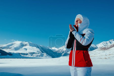 Foto de Joven turista en las montañas calienta sus manos congeladas - Imagen libre de derechos
