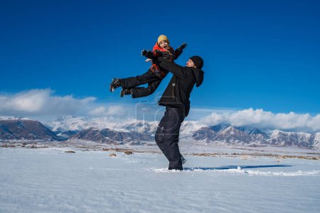 Photo for Father having fun with his son on mountains background in winter - Royalty Free Image