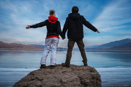 Téléchargez les photos : Homme et femme tenant la main sur fond de lac gelé en hiver - en image libre de droit