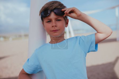Foto de Retrato de chico guapo con gafas de sol en la playa - Imagen libre de derechos