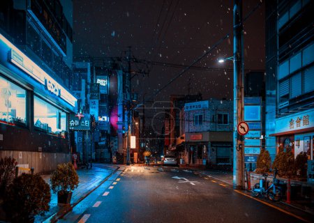 Photo for Seoul, South Korea - February 24, 2024: Seoul street with night bars during a snowfall - Royalty Free Image