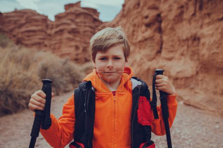 Foto de Retrato de niño excursionista con bastones de trekking en cañón de montaña - Imagen libre de derechos