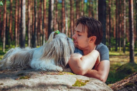 Téléchargez les photos : Jeune homme avec shih tzu portrait de chien en forêt - en image libre de droit