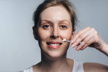 Téléchargez les photos : Portrait de jeune femme tenant une couronne dentaire, concept de dentisterie - en image libre de droit