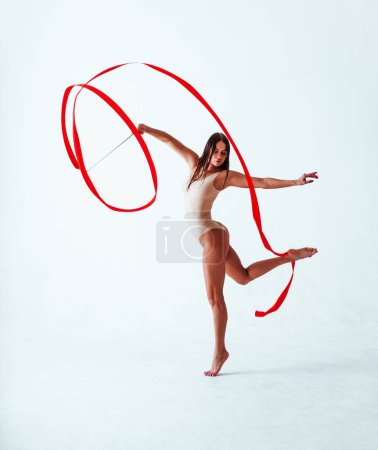Foto de Mujer joven gimnasta con cinta roja sobre fondo blanco - Imagen libre de derechos