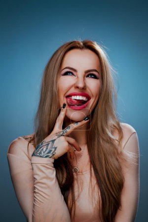 Foto de Young smiling woman emotional studio portrait, tattoo on body - Imagen libre de derechos