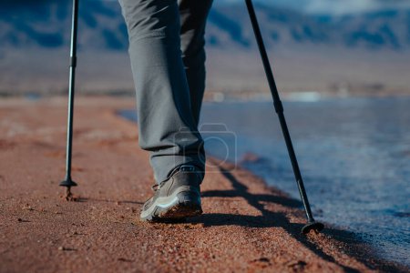 Foto de Mujer camina a lo largo de la orilla arenosa del lago, piernas vista de cerca - Imagen libre de derechos