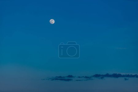 Foto de La luna brilla en el cielo crepuscular con nubes - Imagen libre de derechos