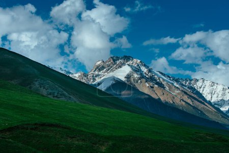 Foto de Pintoresco valle con montañas cubiertas de nieve y prado verde - Imagen libre de derechos