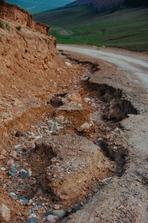 Téléchargez les photos : Destruction d'un chemin de terre après un glissement de terrain dans les montagnes - en image libre de droit