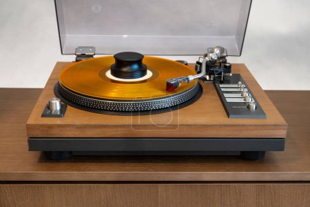 Photo for Vintage Stereo Turntable Vinyl Record Player with Open Plastic Lid and Wooden Plinth Standing on Shelf. Home Retro Audio Sound Equipment - Royalty Free Image