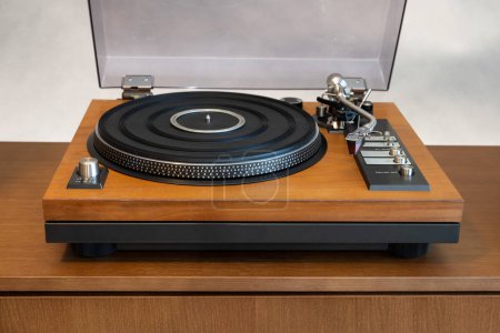 Foto de Reproductor de discos de vinilo giratorio estéreo vintage con tapa de plástico abierta y zócalo de madera de pie en el estante. Inicio Retro Audio Equipo de sonido - Imagen libre de derechos