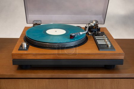 Téléchargez les photos : Lecteur de disque vinyle stéréo vintage avec couvercle en plastique ouvert et socle en bois debout sur l'étagère. Accueil Équipement audio rétro - en image libre de droit