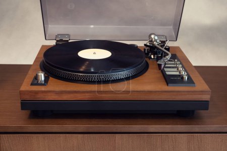 Foto de Reproductor de discos de vinilo giratorio estéreo vintage con tapa de plástico abierta y zócalo de madera de pie en el estante. Inicio Retro Audio Equipo de sonido - Imagen libre de derechos