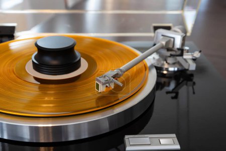 Foto de Vintage Stereo Turntable Vinyl Record Tonearm Cartridge Primer plano. Stylus vuela por encima de registro de color con pinza con peso. - Imagen libre de derechos