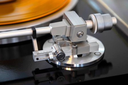 Téléchargez les photos : Vintage Stereo Turntable Vinyl Record Tonearm Mécanisme Gros plan. Pièces métalliques brillantes de la composante mécanique complexe. - en image libre de droit
