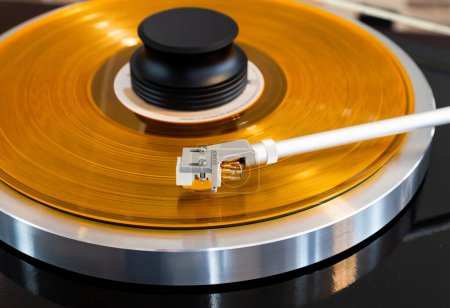Photo for Vintage Stereo Turntable Record Player Tonearm Above Yellow Colored Vinyl - Royalty Free Image