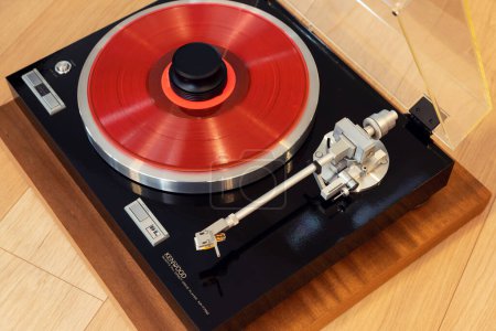 Foto de Reproductor de discos de mesa giratoria estéreo vintage con disco de colores y abrazadera de peso - Imagen libre de derechos