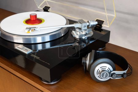 Foto de Reproductor de discos de mesa giratoria estéreo Kenwood Vintage con disco de color blanco, auriculares y almeja de peso - Imagen libre de derechos