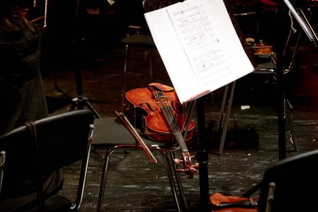 Foto de Imagen de un instrumento de cuerda de madera violín se encuentra en una silla - Imagen libre de derechos