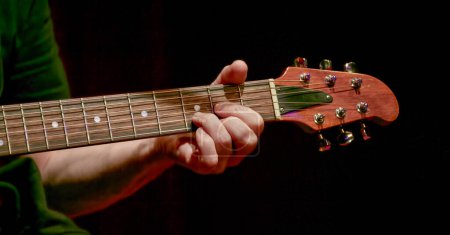 Photo for Image of fingers taking a chord on the fretboard of an acoustic guita - Royalty Free Image