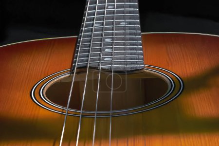 Photo for Image of a resonant hole in the soundboard of a guitar neck with strings - Royalty Free Image