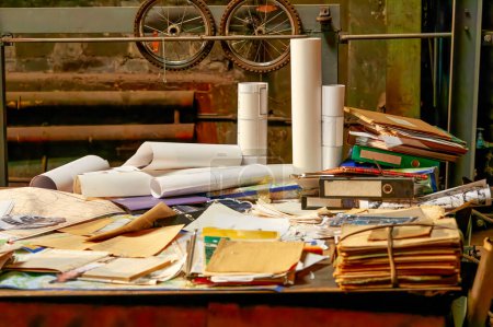Photo for Image of a large table in a workshop littered with old drawings and folders - Royalty Free Image