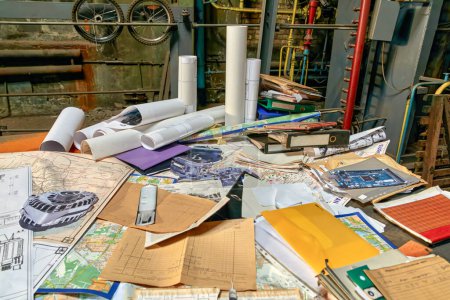 Photo for Image of a large table in a workshop littered with old drawings and folders - Royalty Free Image